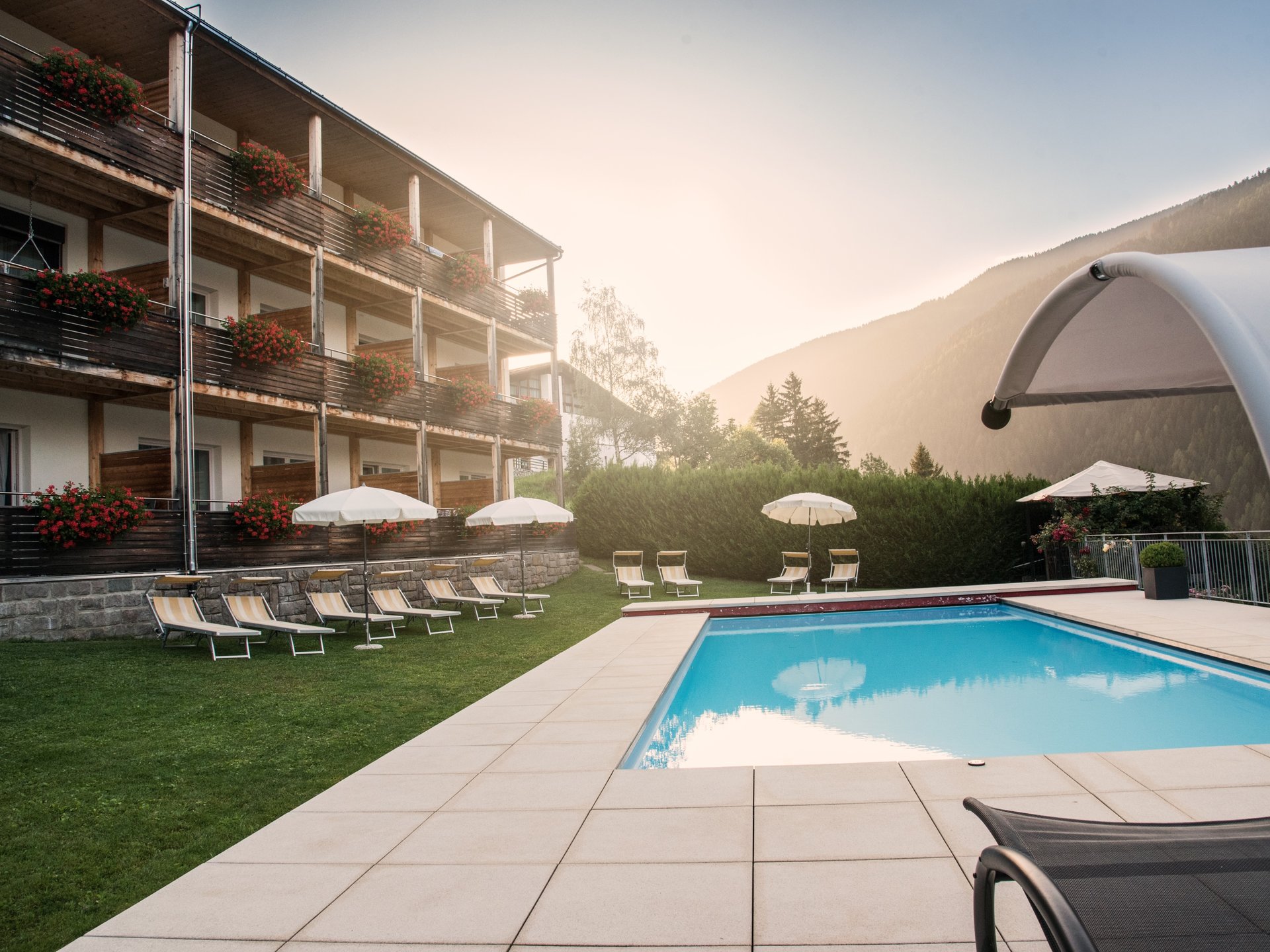 Sonnig, zentral und ruhig gelegenes Hotel im Ultental (Südtirol) mit Schwimmbad, Garten, Wellnessbereich und Blick auf die Berge.