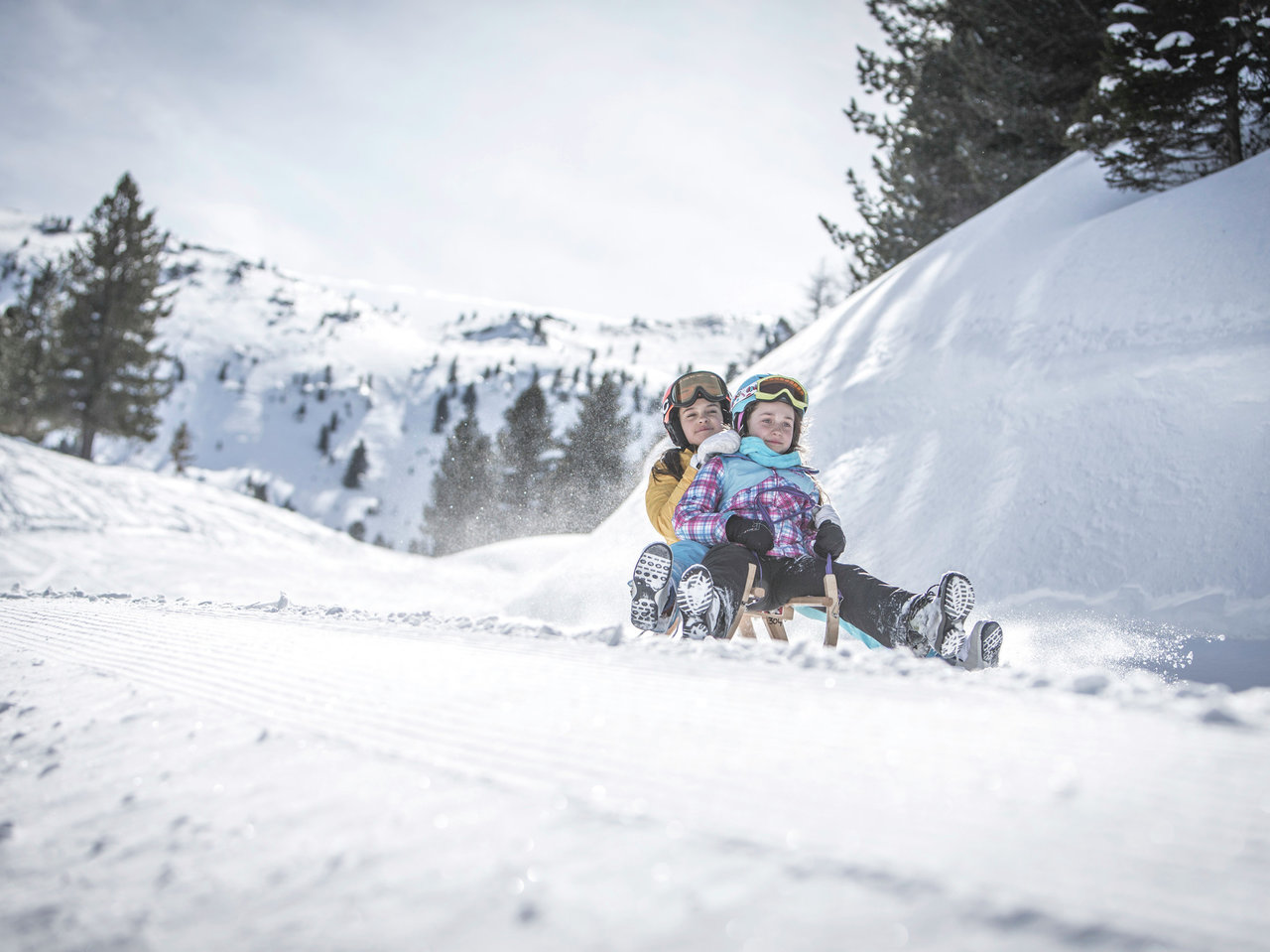 happy children sledding in snowy landscape